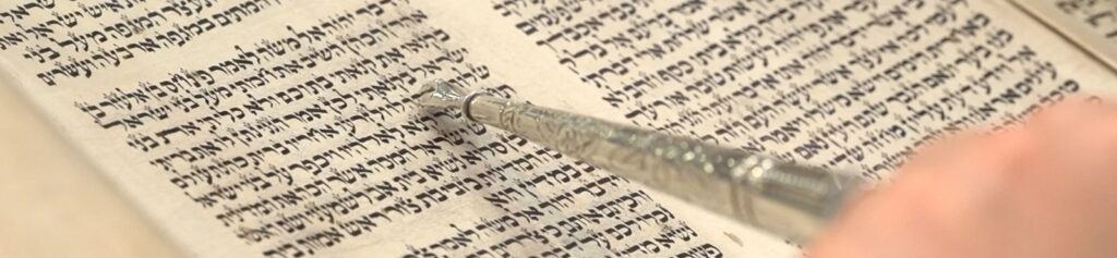 An image of a page of the torah where the parsha "pinhas" begins.